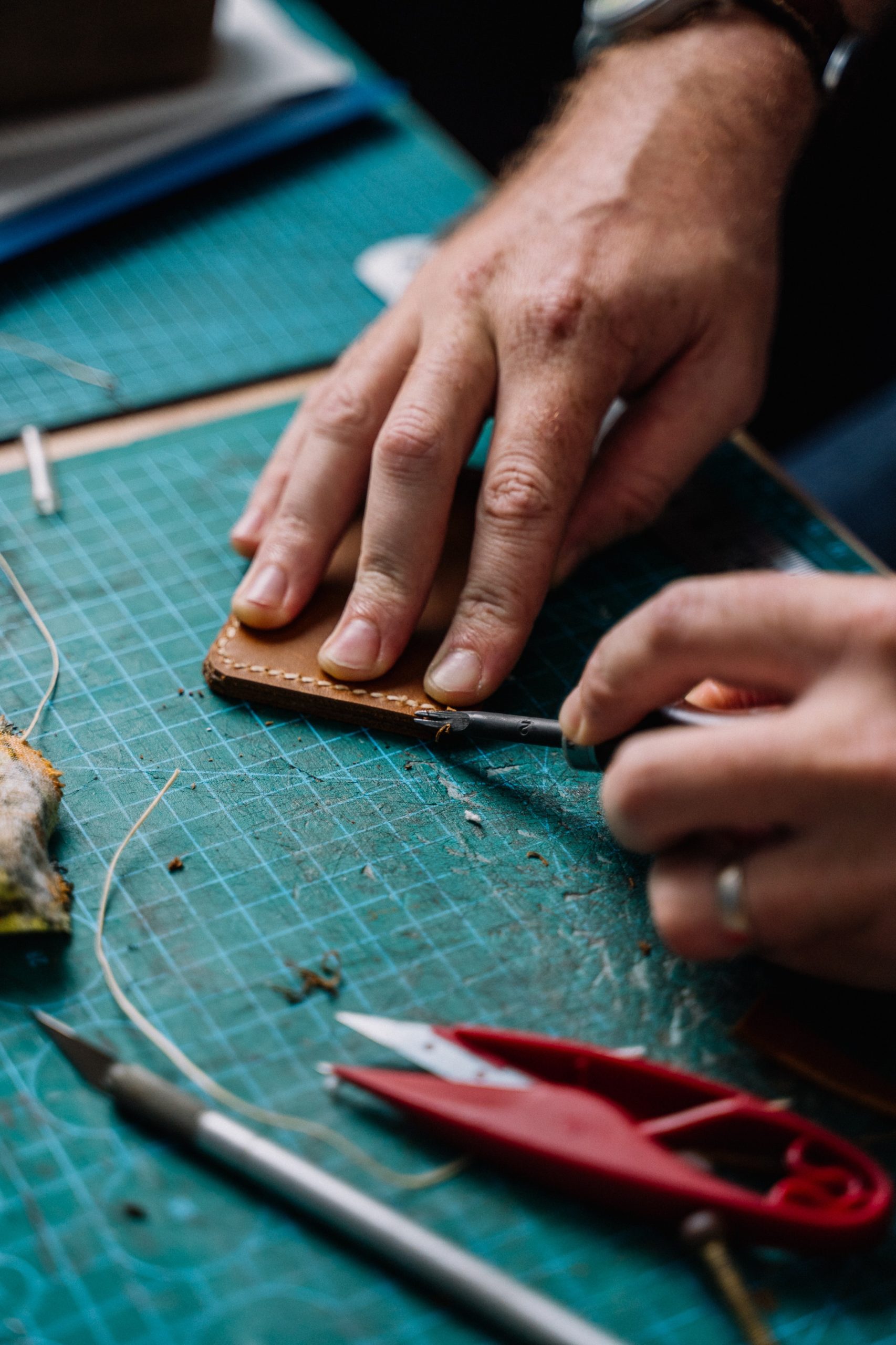 Les mains d'un artisan sellier